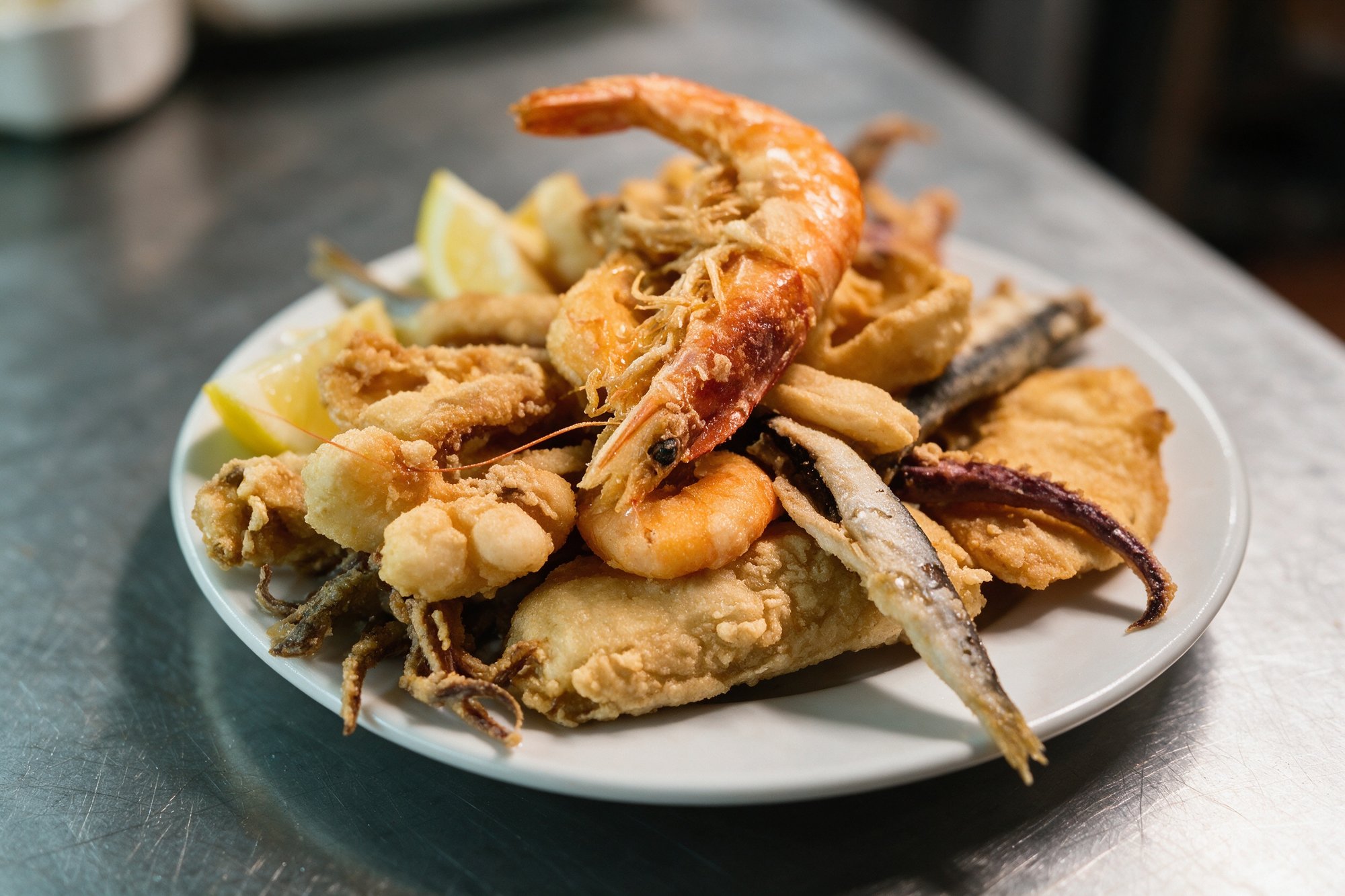 Fritura de pescado de Fondeo Playa, mezcla andaluza de pescado frito con rebozado crujiente y limón